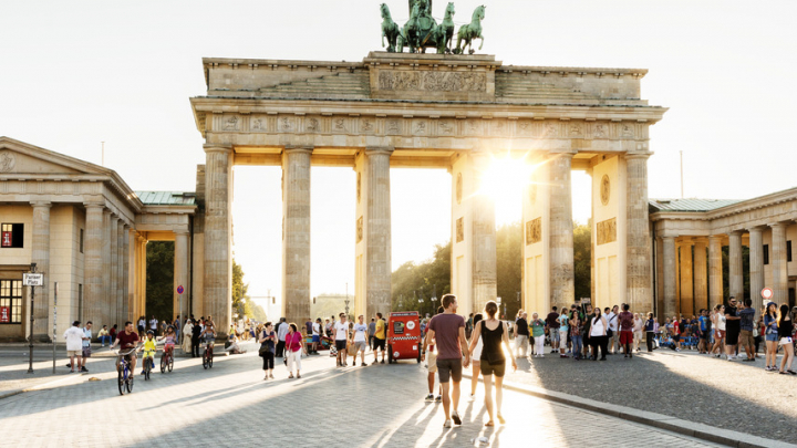 Menschen schlendern durch das Brandenburger Tor, ein Wahrzeichen von Berlin.